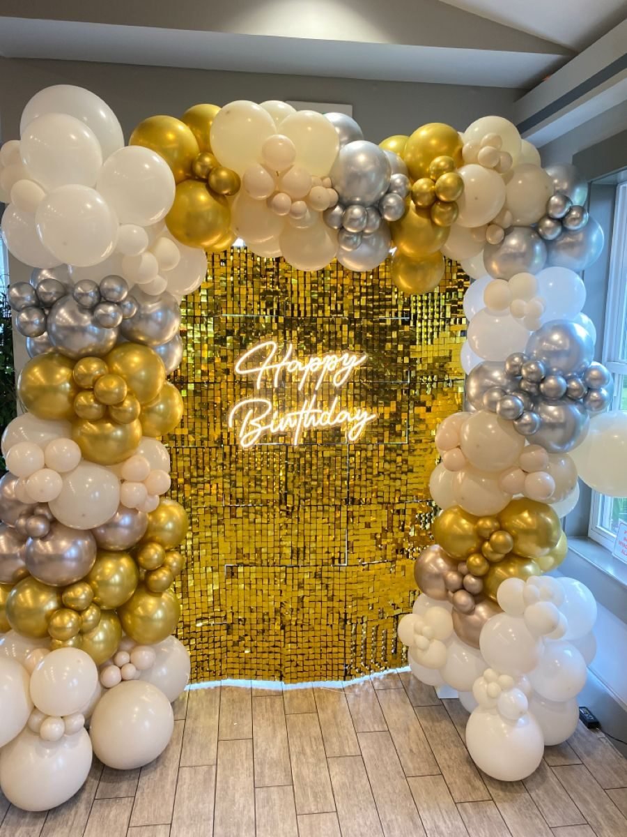 Gold and white balloon arch with Happy Birthday sequin backdrop
