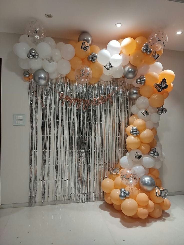 Orange and white balloon arch with butterflies